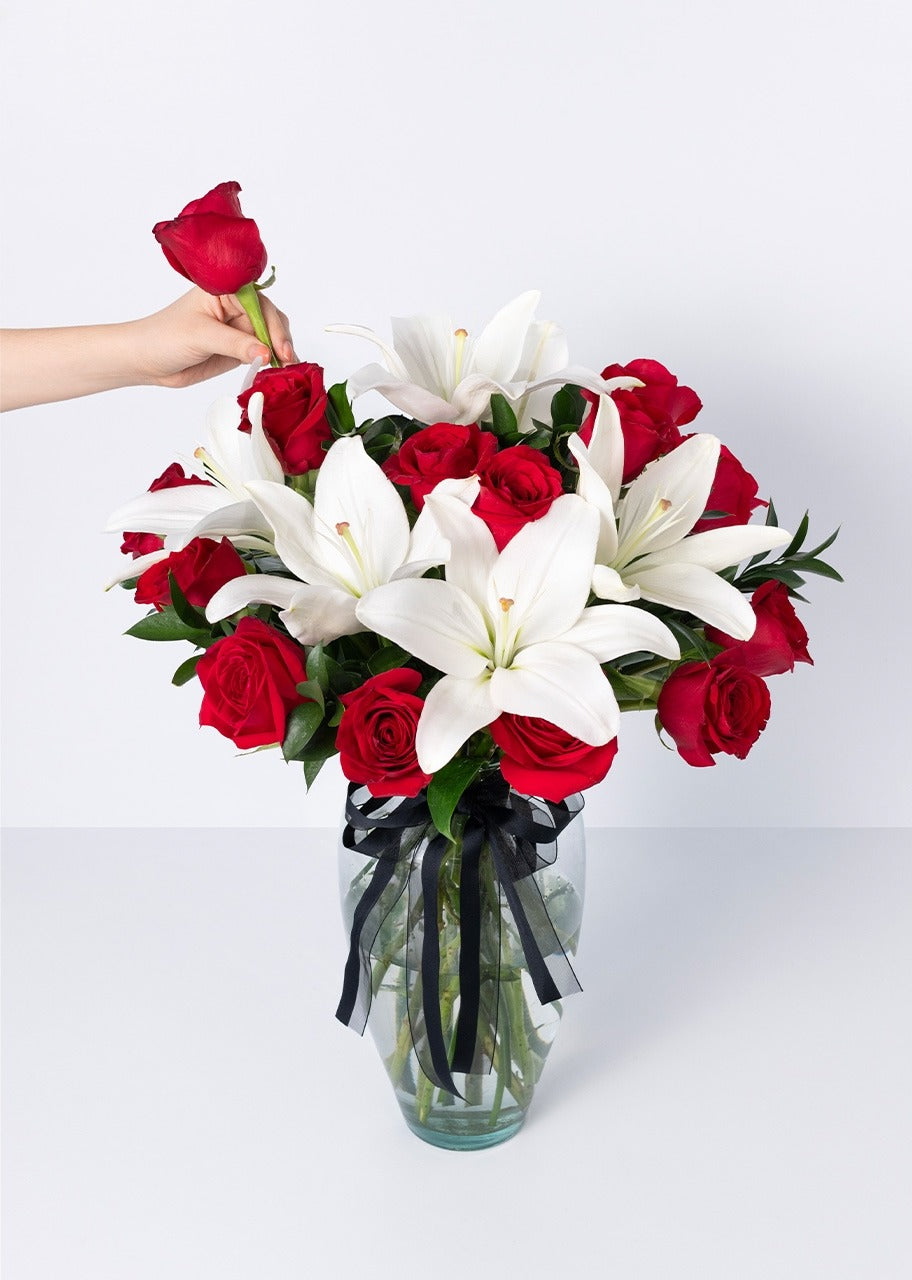 15 rosas rojas y lilys en jarrón