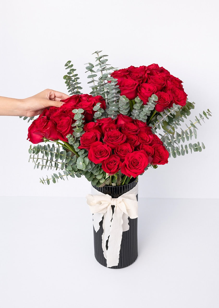 50 rosas rojas en jarrón negro