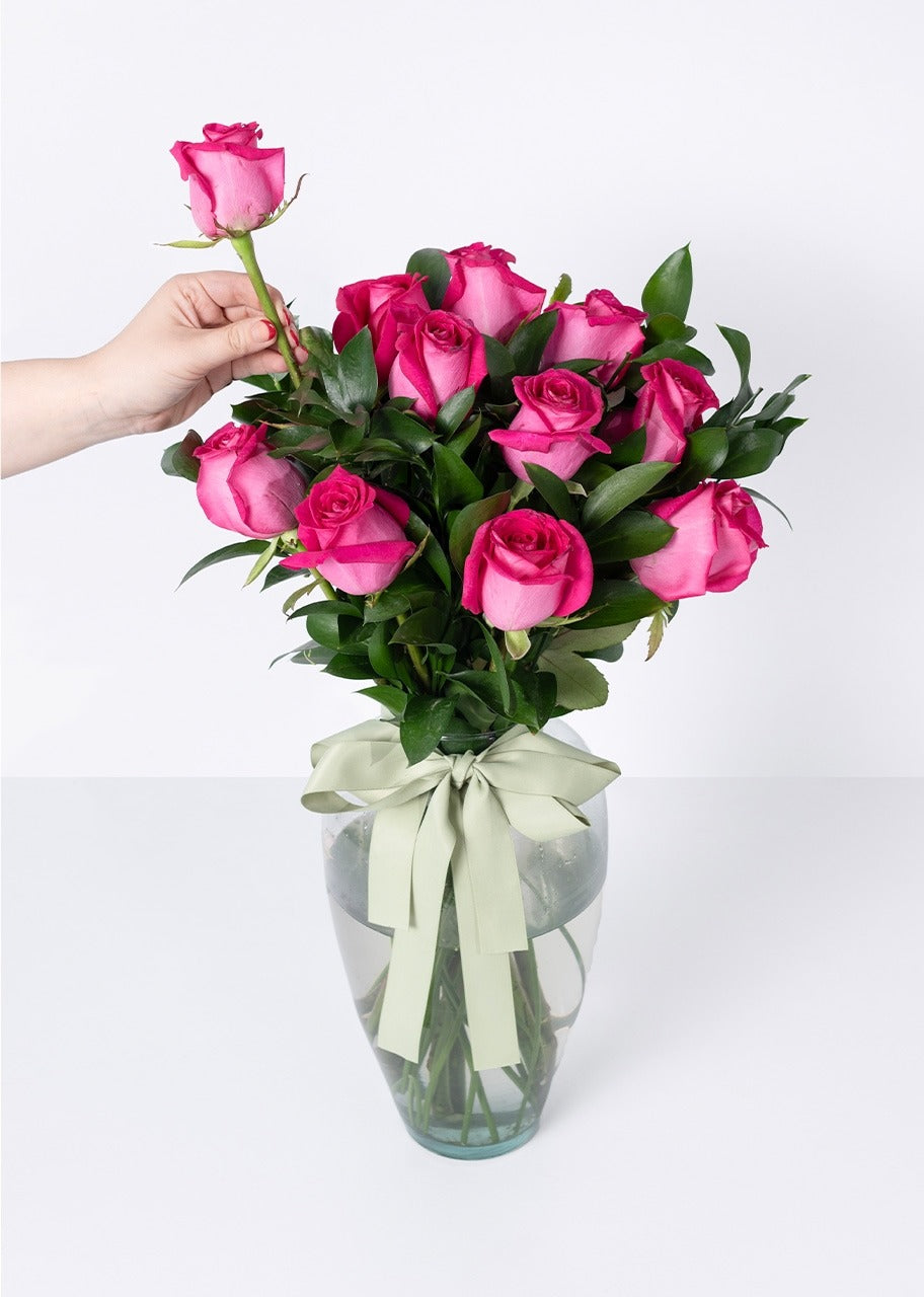 12 rosas fucsia en jarrón