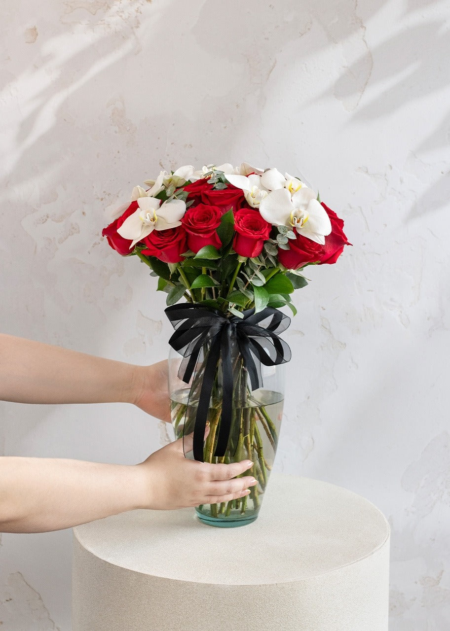 24 rosas rojas y orquídea en jarrón