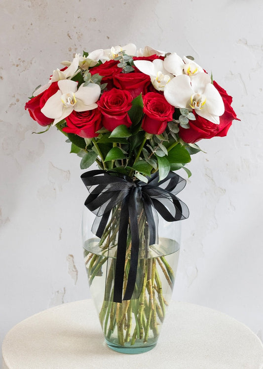 24 rosas rojas y orquídea en jarrón