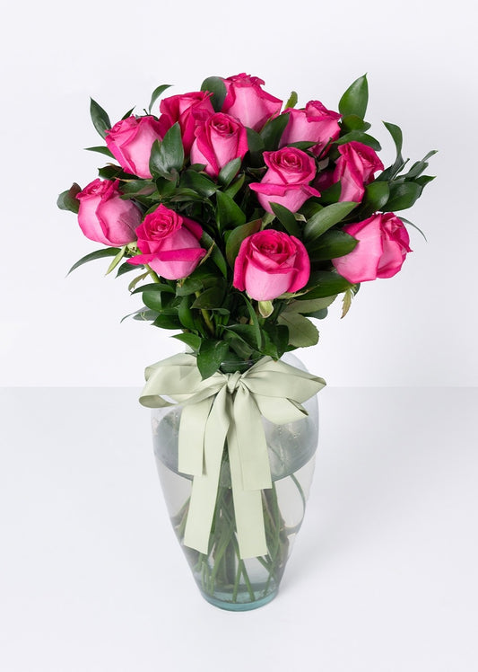 12 rosas fucsia en jarrón