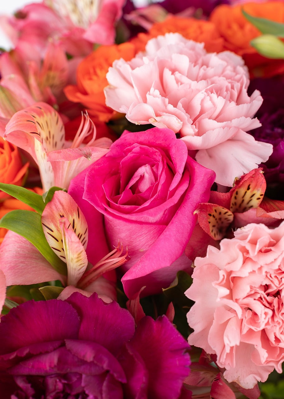 10 rosas naranjas y clavel en jarrón